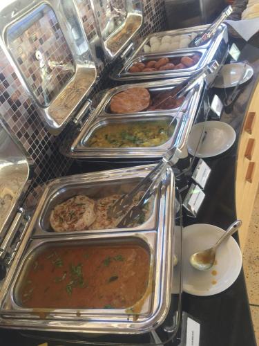Bodhiwoods Resorts في مهاباليبورام: بوفيه مع العديد من الصواني من مختلف أنواع الطعام