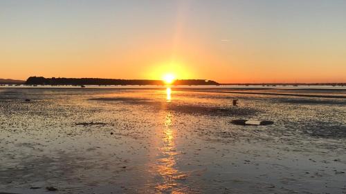 a sunset on a beach with the sun setting at Turlin Valley in Poole