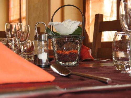 a table with a vase with a white flower in it at Hôtel Restaurant de l'Abbaye in Clairvaux