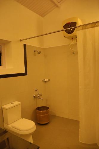 a bathroom with a toilet and a shower at The Tamarillo in Ooty