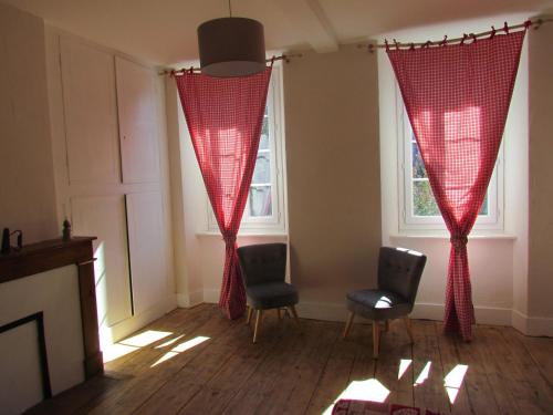 a living room with two chairs and red curtains at Le domaine des 3 marmottes Chambres d' hôtes in Cierp