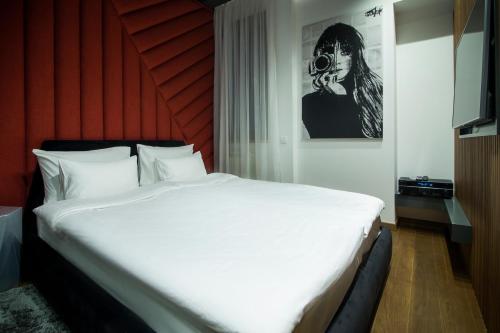 een slaapkamer met een groot wit bed in een kamer bij Little Dubai in Belgrado