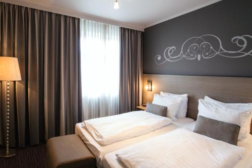 a hotel room with two beds and a window at Grand Hotel Monopole in Valkenburg