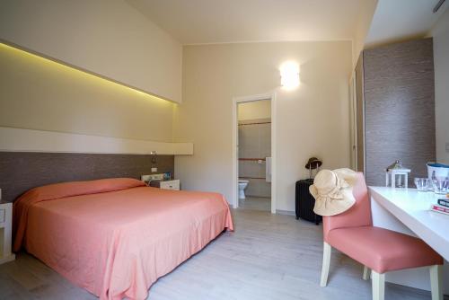 a bedroom with a bed and a desk with a chair at Solemare Club Village in Capo Vaticano