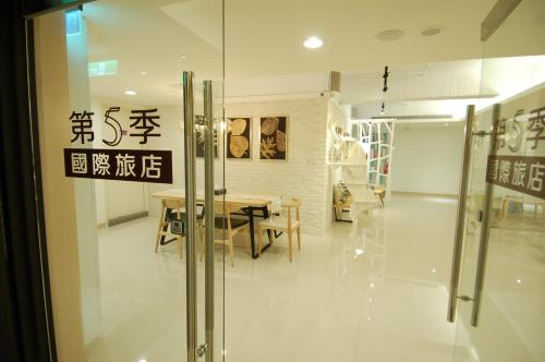 a dining room with a table and a glass door at Season 5 Inn in Luodong