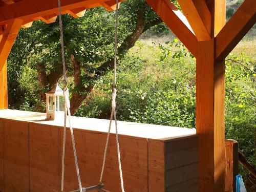 a porch swing with ropes and a bird house at Chalet in Germany with Fireplace & Terrace in Schönecken