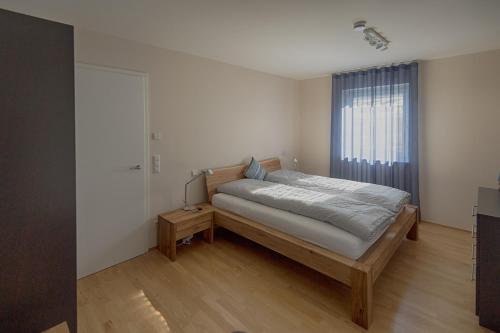 ein Schlafzimmer mit einem Bett und einem großen Fenster in der Unterkunft FeWo "Staufen Lodge" Oberstaufen in Oberstaufen