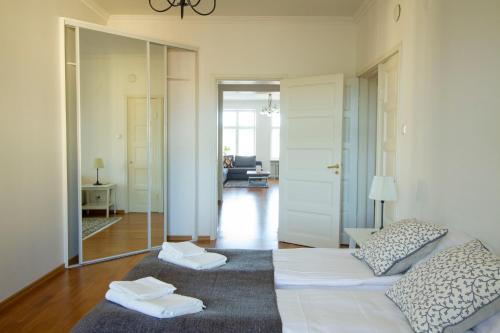 een woonkamer met 2 bedden en een spiegel bij 2ndhomes Stunning Top Floor Residence with Sauna and Balcony in Helsinki