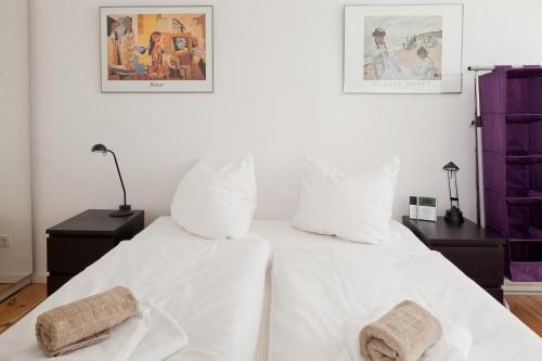 Una cama blanca con sábanas blancas y toallas. en Schloss Apartment, en Berlín
