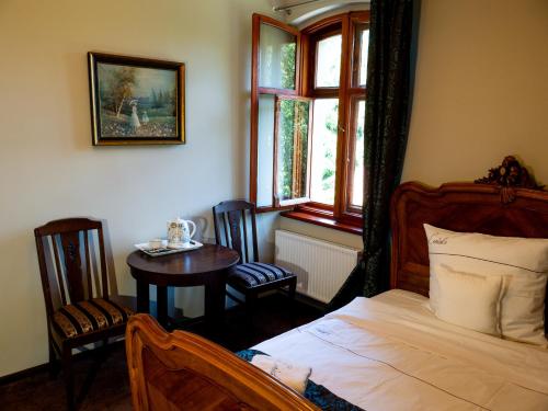 a bedroom with a bed and a table and a window at Leniwka in Świebodzin