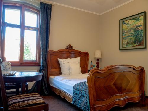 um quarto com uma cama, uma mesa e uma janela em Leniwka em Świebodzin