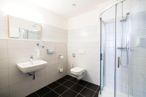 ein Bad mit einem WC, einem Waschbecken und einer Dusche in der Unterkunft Hotel Koflík in Strakonice