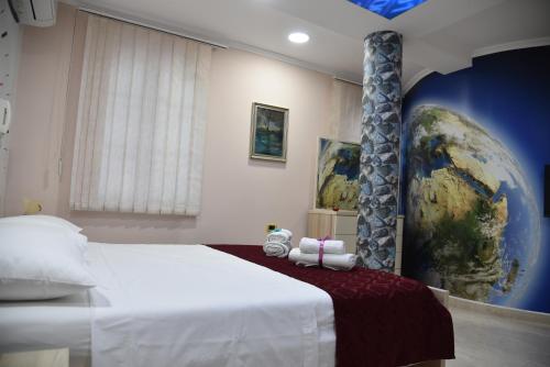 um quarto com uma cama grande e um globo na parede em Alindro City Center Apartment em Tirana