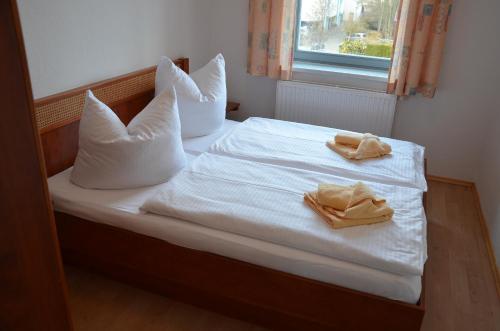 ヘリングスドルフにあるVilla Inge Appartement 10のベッド1台(白いシーツ、タオル2枚付)