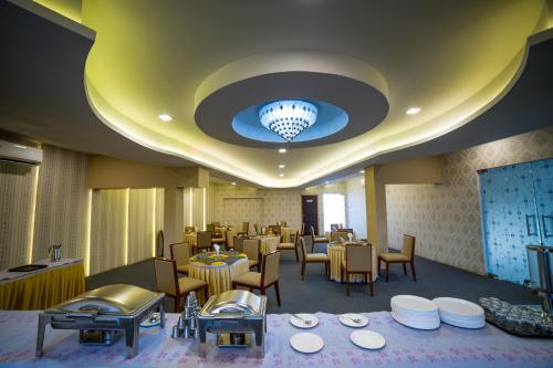 um restaurante com mesas e cadeiras e um lustre em Hotel President em Madurai