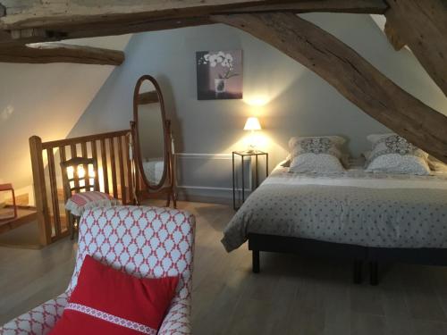une chambre avec un lit et une chaise dans l'établissement Aux Cornettes, à Beaune