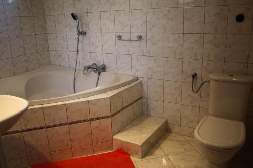 a bathroom with a tub and a toilet and a sink at Ubytování Markéta in Perná