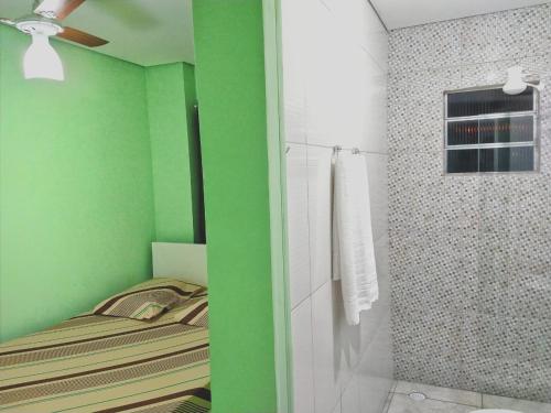 a green bathroom with a bed and a shower at HOTEL KISS - TABOÃO DA SERRA in Taboão da Serra