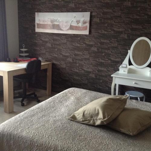 a bedroom with a bed and a desk and a mirror at Guesthouse De Steenberg tweepersoonskamer met grote badkamer, kitchenette en tuinzicht op de eerste verdieping in Geel