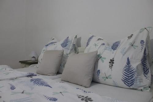 a bed with blue and white pillows on it at Patrícia Pihenőház in Alsónána