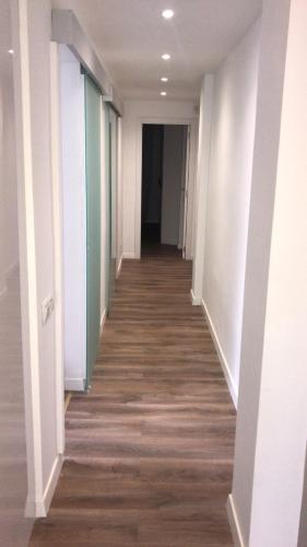 a hallway of an office building with white walls and wood floors at Céntrico ,Moderno y confortable Apartament in Almería