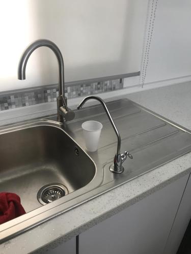 a sink in a kitchen with a cup in it at Céntrico ,Moderno y confortable Apartament in Almería