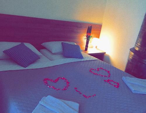 a bed with hearts written on it in a bedroom at Guest House Hello in Kutaisi