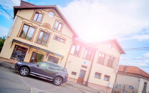 a car parked in front of a building at Pensiunea Un Baiat si o Fata in Cîmpulung