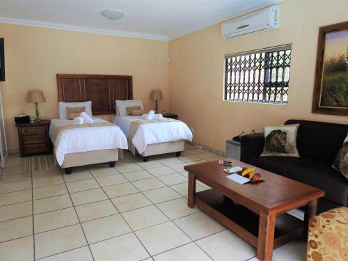 a living room with two beds and a couch at Ubuntu Bed and Breakfast in Marloth Park