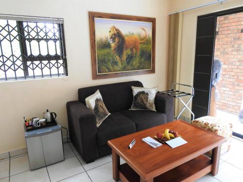 a living room with a couch and a table at Ubuntu Bed and Breakfast in Marloth Park