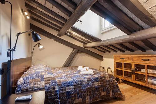 a bedroom with a bed and a desk with a lamp at Loft Navona in Rome