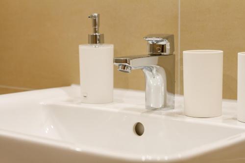 a bathroom sink with a faucet and two rolls of toilet paper at Ferienwohnungen Alpentraum - Hörnernest in Bolsterlang