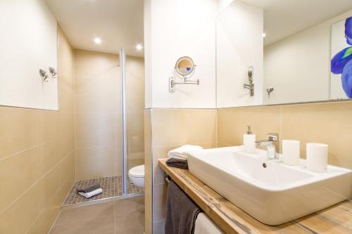 a bathroom with a sink and a shower at Ferienwohnungen Alpentraum - Hörnernest in Bolsterlang