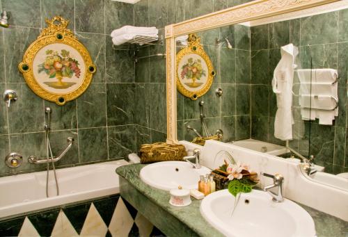 a bathroom with a sink, mirror, and bathtub at Grand Hotel Des Iles Borromees in Stresa