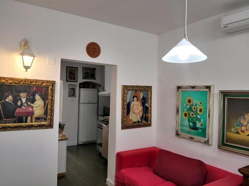 バーリにあるCasa verdeのリビングルーム(壁画、赤いソファ付)