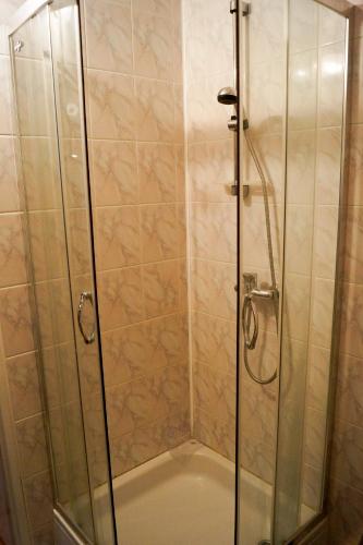 uma cabina de duche com uma porta de duche envidraçada em Emilka em Suwałki