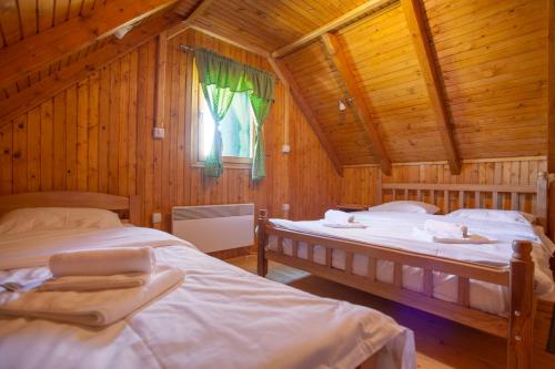 1 Schlafzimmer mit 2 Betten in einer Holzhütte in der Unterkunft Woodland ABC in Žabljak