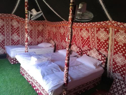 two beds in a tent with white sheets at Oman desert private camp in Shāhiq