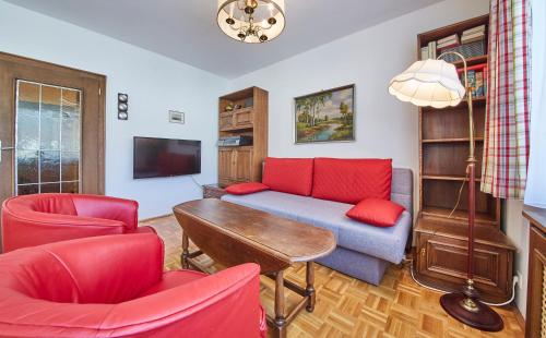 a living room with a blue couch and red chairs at Appartement Retreat in Saalbach Hinterglemm