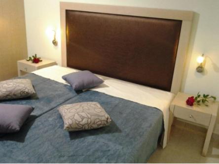 a bedroom with a large bed with two pillows on it at 4S Beach Superior Apartments in Stalida