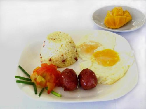 a plate of food with eggs and fruit on a table at Sulu Plaza in Boracay