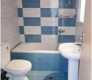 a blue and white bathroom with a toilet and a sink at 4S Beach Superior Apartments in Stalida