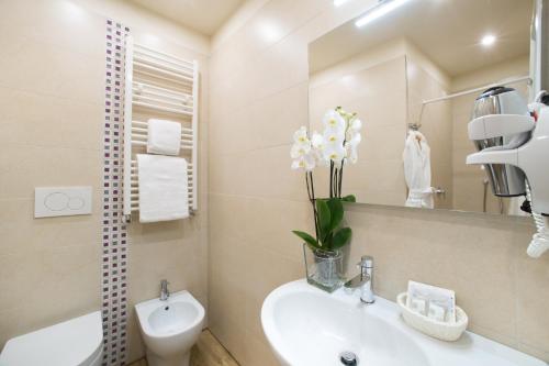 a bathroom with a sink and a toilet and a mirror at Hotel Montreal in Florence
