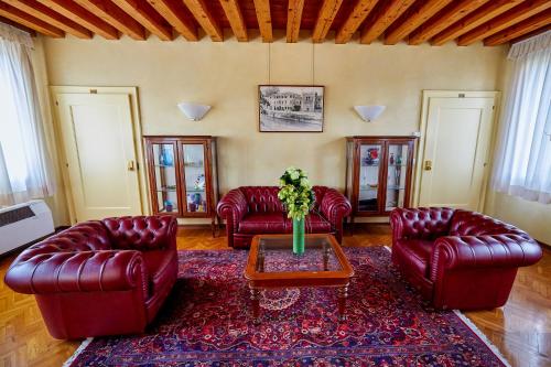 a living room with red leather furniture and a table at Hotel Riviera dei Dogi in Mira