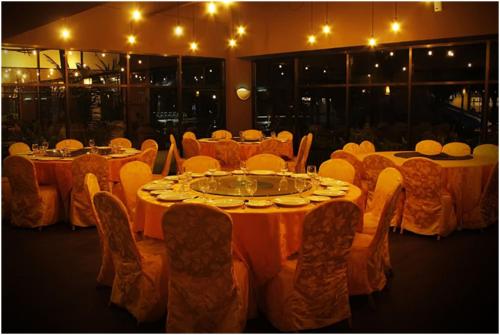 a dining room with tables and chairs at ZamLan Gold Coast Morib Intl Resort - 3 Rooms Apartment in Banting