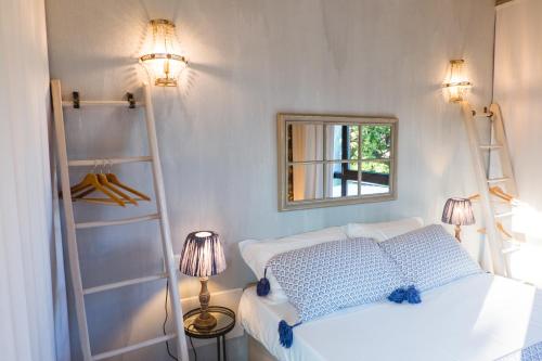 Schlafzimmer mit einem weißen Bett und einem Spiegel in der Unterkunft Villa Colli Storici in Desenzano del Garda
