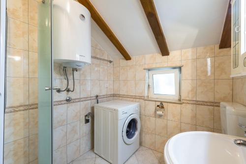 ein Badezimmer mit Waschmaschine und Waschbecken in der Unterkunft Apartments Villa Kulish in Cavtat