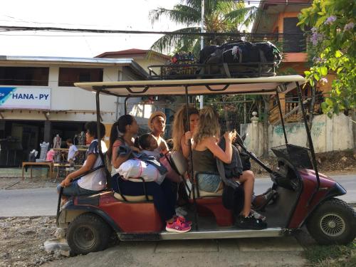 a group of people sitting on a golf cart at The VRNON Boutique by MY hostel in Boracay