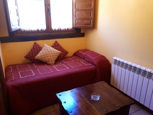 a living room with a purple couch and a table at Posada La Vieja Escuela in San Roque de Ríomiera
