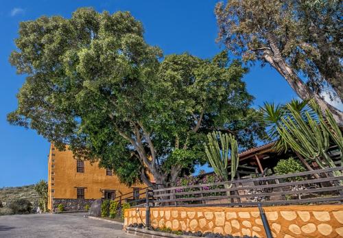 un edificio con árboles y una valla delante de él en Hotel Rural LIVVO Maipez en Las Palmas de Gran Canaria